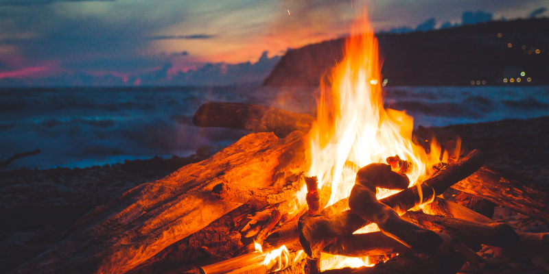 Beach Bonfires Image shows a large bonfire against a blurred beach background.