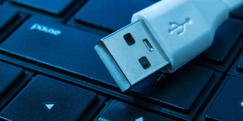 Include Technical Amenities Like Chargers and Streaming Ending of a charger cord sitting on top of a computer keyboard.