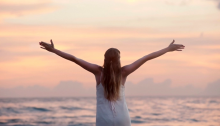 girl opening arms toward ocean