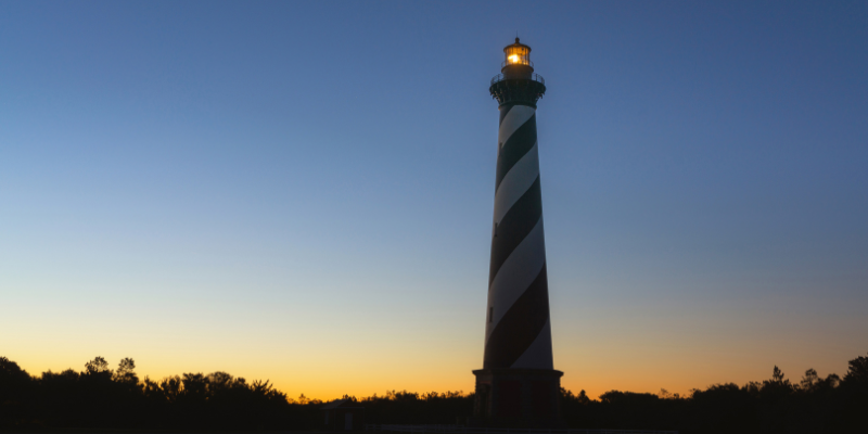 Cape Hatteras Lighthouse at Sunset Black and white lighthouse with a burning light at sunset.