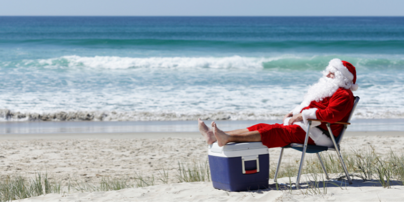 Santa at the Beach A man dressed as Santa sits on an Outer Banks beach with his feet propped up on a cooler.