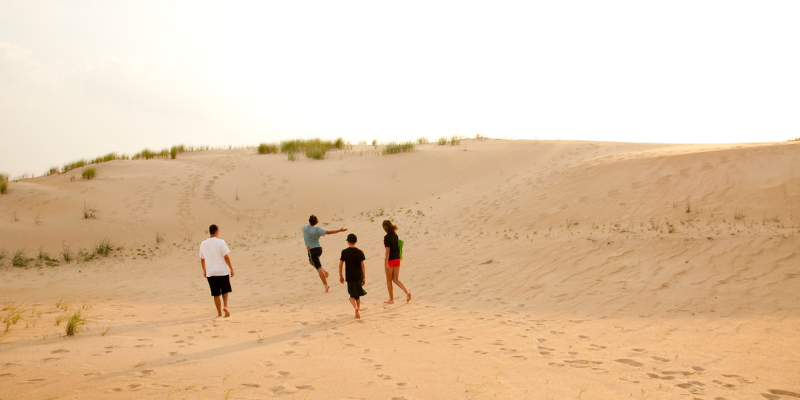 Take a Trip to Jockey's Ridge State Park with the Family! Family walking on the sand dunes.